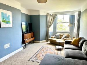 a living room with a couch and a tv at Gensing Garden Apartment in Hollington