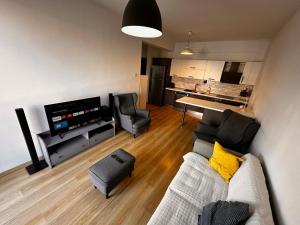 ein Wohnzimmer mit einer Couch, einem Fernseher und einem Tisch in der Unterkunft Kyrenia Kavanlar life village 2 bedroom swimming pool in Kyrenia