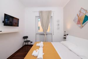 a white bedroom with a bed with white towels at Ostia Bella Apartment in Lido di Ostia