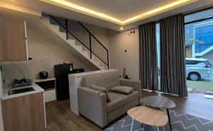 a living room with a chair and a stair case at Villa Panderman Batu Malang in Batu