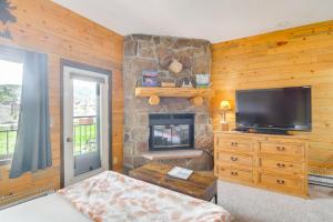 格兰比2 Mi to Granby Ranch Mtn Condo with Hot Tub!的客厅设有壁炉和平面电视。