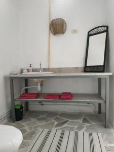 a bathroom with a bench with a mirror and a sink at ZINA RESORT camping touristique in Zurayq Barrānīyah