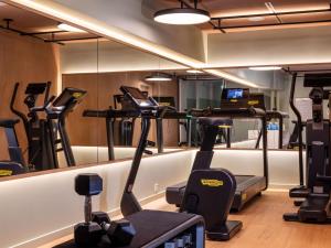 a gym with treadmills and elliptical machines at Hôtel De Sers Champs Elysées Paris in Paris