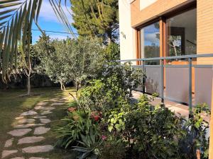 un jardin à côté d'une maison plantée d'arbres et de buissons dans l'établissement Casa Tres Cales, à L'Ametlla de Mar