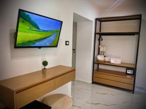a living room with a flat screen tv on a wall at Dine Hotel in Ksamil