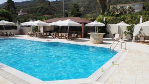 a large swimming pool with chairs and umbrellas at Leonidas Apartments & Suites 2 in Mola Kalyva