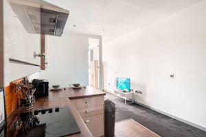 a kitchen with white walls and a stove top oven at Central Blackburn Convenient 1 Bedroom Apartment in Blackburn