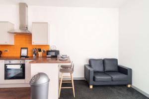 a kitchen with a black chair and a table at Central Blackburn Convenient 1 Bedroom Apartment in Blackburn