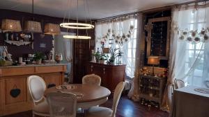 a dining room with a table and chairs and a kitchen at le 7 pompadour in Pompadour