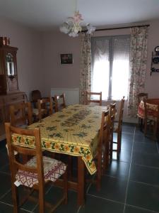 ein Esszimmer mit einem Tisch und Stühlen und einer Tisch- und Stuhlplatte in der Unterkunft A la maison in La Chaussée-sur-Marne