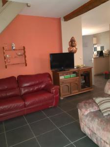 ein Wohnzimmer mit Couch und Flachbildfernseher in der Unterkunft A la maison in La Chaussée-sur-Marne