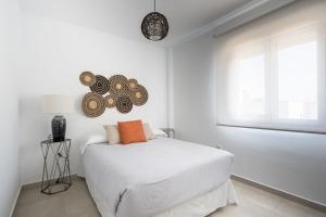een witte slaapkamer met een bed en een raam bij Balcones Olehousing in Conil de la Frontera