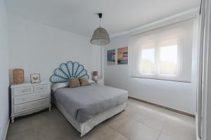 een witte slaapkamer met een bed en een raam bij Balcones Olehousing in Conil de la Frontera +20 foto's