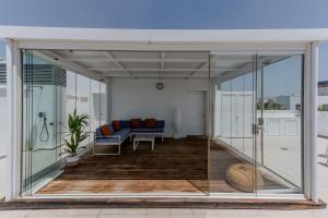 een woonkamer met glazen deuren en een bank bij Balcones Olehousing in Conil de la Frontera