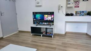 a flat screen tv sitting on a stand in a room at Un pied-à-terre in Millau