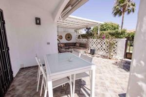 ein weißer Tisch und Stühle auf einer Terrasse in der Unterkunft Deluxe Los Porches - by Gestión Vacacional Canarias in Playa del Ingles