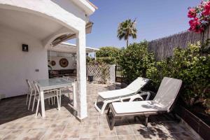 eine Terrasse mit einem Tisch und Stühlen auf einer Terrasse in der Unterkunft Deluxe Los Porches - by Gestión Vacacional Canarias in Playa del Ingles