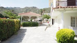 a white house with a gazebo in a yard at Leonidas Apartments & Suites 2 in Mola Kalyva