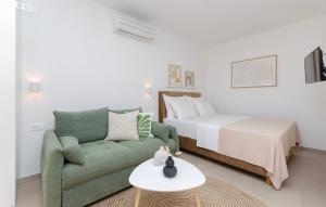 a living room with a bed and a green couch at Apartments and Rooms Kapulica in Tučepi