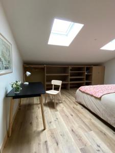 Un dormitorio con un escritorio y una cama con tragaluz. en Maison 4 Personnes, jardin, piscine La Rochelle, en Lagord 17 fotos más