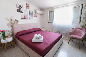 a bedroom with a pink bed and a pink chair at L'albero di Beatrice in Quartu Sant'Elena