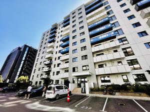 una furgoneta blanca estacionada en un estacionamiento frente a un edificio en Urban Nest Pipera, en Pipera