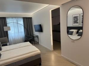 una habitación de hotel con una cama y un espejo en Urban Nest Pipera, en Pipera