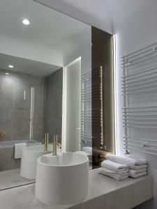 Un baño blanco con lavabo y espejo. en Urban Nest Pipera, en Pipera