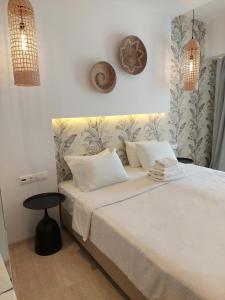 a bedroom with a white bed with a black stool at Hotel Alexandra in Skala