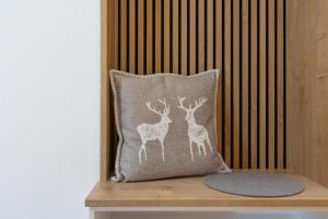 a pillow with deer on it sitting on a shelf at Ferienwohnung "Mettmatalblick" mit privater Sauna, Ühlingen-Birkendorf in Ühlingen-Birkendorf
