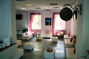 una sala de estar con sofás y un reloj en la pared en Hotel Santa Marta en Pozzuoli
