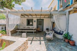 a patio with a table and a swing at Lampi's House in Patmos