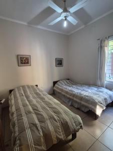 a bedroom with two beds and a ceiling fan at Departamento Loteo La Plaza in Rivadavia