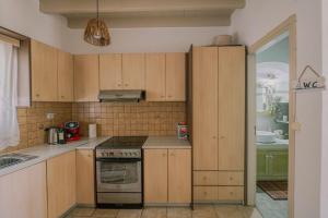 a kitchen with wooden cabinets and a stove top oven at Lampi's House in Patmos
