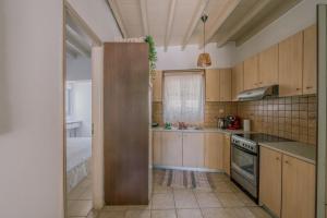 a kitchen with wooden cabinets and a stove top oven at Lampi's House in Patmos