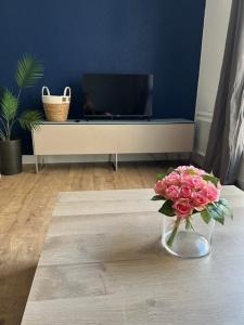セットにあるAppartement T2 proche gare et centre villeのリビングルームのテーブルに飾られたピンクの花瓶