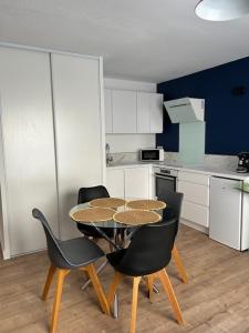 セットにあるAppartement T2 proche gare et centre villeの部屋にテーブルと椅子のあるキッチン +2枚の写真