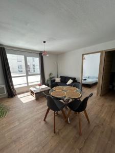 セットにあるAppartement T2 proche gare et centre villeのテーブルと椅子とソファのあるリビングルーム
