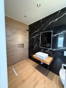 a bathroom with a sink and a black wall at Hotel Imperial in Spille +43 photos