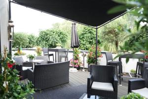 a patio with chairs and tables and an umbrella at Villahotel Rheinblick in Cologne