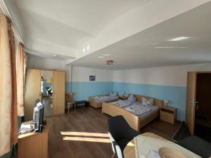 a living room with two beds and a tv at Ferienwohnungen Hennig in Ahlbeck