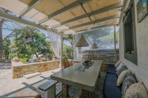 a patio with a table and a large window at Lampi's House in Patmos