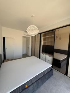 een slaapkamer met een bed en een kroonluchter bij Bord de mer exceptionnel in Marseillan