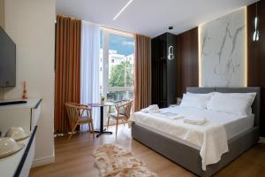ein Schlafzimmer mit einem Bett und einem Tisch mit Stühlen in der Unterkunft Gamma Hotel Durres - FREE PARKING & SUNBEDS in Durrës + 270 Fotos
