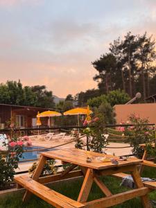 a wooden picnic table sitting next to a pool at Atlas Bungalows in Kumluca +46 photos