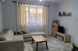 a living room with a couch and a window at Brayan guest house in Pogradec
