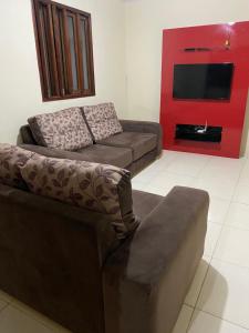a living room with a couch and a flat screen tv at Casa Vó Anastacia in Piranhas