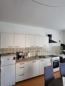 a kitchen with white cabinets and a sink at Apartma Magdalena in Kobarid