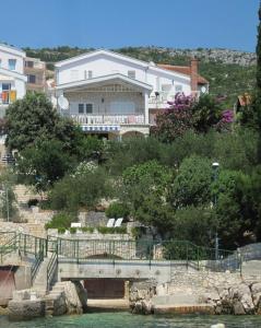 una casa en una colina junto a un cuerpo de agua en Apartments Mediteraneo, en Klek