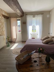 a bedroom with a bed and a table with flowers on it at La Gouronerie in Parçay-sur-Vienne +22 photos